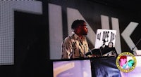 a man standing in front of a dj booth at an event