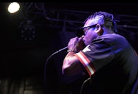 a man with glasses singing into a microphone