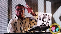 a man with glasses and a microphone in front of a dj booth