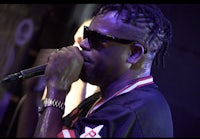 a man in sunglasses is holding a microphone