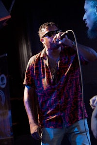 a man is singing into a microphone while another man is holding a microphone