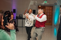 a group of people dancing at a wedding reception