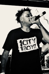 a black and white photo of a man singing into a microphone